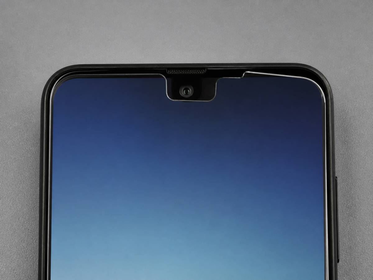 保護フィルムの端が画面上部のセンサー付近にずれているスマートフォンの接写
